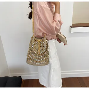 Dettaglio della borsa a secchiello stile punk con borchie dorate e strass brillanti.