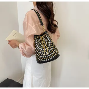 Dettaglio borsa a secchiello nera stile punk con strass scintillanti e borchie