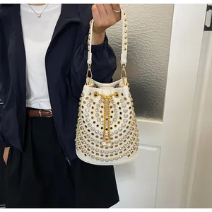 Dettaglio della borsa a secchiello bianca punk con cristalli e borchie dorate