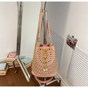 Elegante borsa a secchiello punk rosa con occhielli dorati e borchie in cristallo lucido