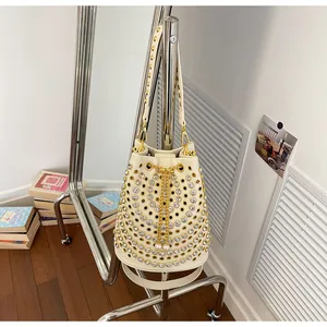 Secchiello stile punk con strass scintillanti e borchie dorate appeso a un rack