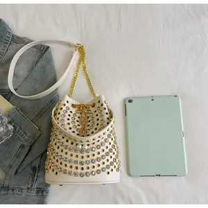 Vista dettagliata della borsa a secchiello bianca stile punk con borchie e strass su tablet