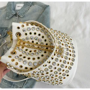 Vista macro dettagliata della borsa a secchiello punk bianca con strass e borchie dorate