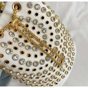 Vista macro della borsa punk bianca con strass trasparenti e catena dorata
