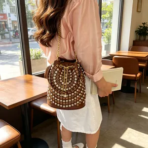 Borsa a secchiello in pelle marrone stile punk con strass e catena dorata da donna.
