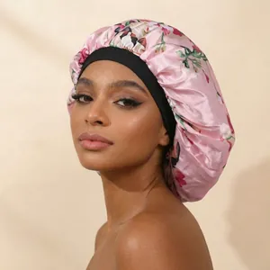 Close-up of large pink floral satin sleep bonnet with a wide black elastic hair band.