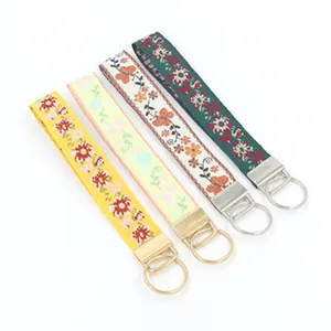 Detailed view of four colorful ethnic style embroidered wristlet keychains with floral motifs