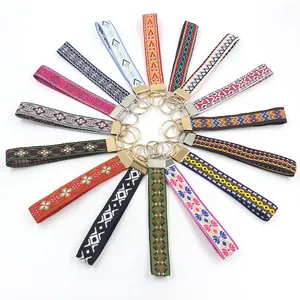Colorful bohemian embroidered ribbon keychains displayed in a radial pattern on white background