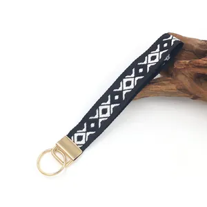Cordino da polso ricamato in stile etnico bianco e nero con anello dorato per chiavi