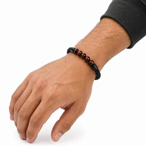 Dettaglio del bracciale in pelle intrecciata nera con pietre occhio di tigre rosso da 6 mm.