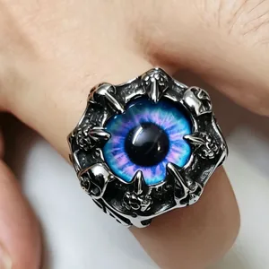 Macro detail of a retro punk stainless steel dragon claw ring with a vivid blue eye inlay.