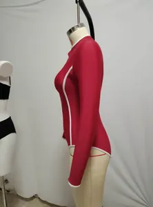Side view of red long-sleeved one-piece surf suit with white piping details on mannequin