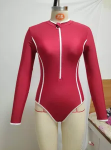Close-up front view of red long sleeve one-piece surf suit with white contrast lines
