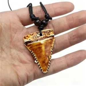 Vue détaillée du collier tribal en résine dent de requin avec finition vieillie