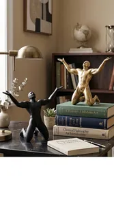 Detailed view of artistic Nordic style kneeling male sculptures in gold and black finishes