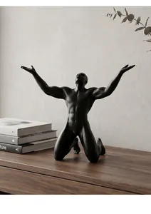 Artistic detail of black matte muscle man sculpture in a kneeling pose for modern home decor