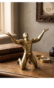 Close-up of a bronze muscular male sculpture kneeling on a vintage dark wooden desk