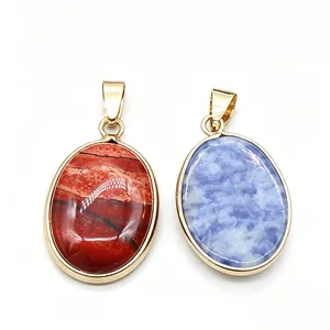 Pair of oval natural stone pendants with gold-plated edging in jasper red and sodalite blue