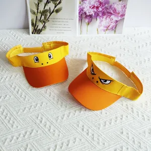 Detail of yellow and orange visor hats with funny embroidered cartoon eyes on white fabric