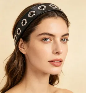 Detailed close-up of a wide black PU leather headband with silver metal eyelet grommet design