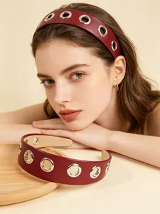 Close-up of a model wearing a burgundy PU leather wide headband with silver metal grommets