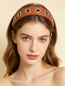 Elegant brown wide PU leather headband featuring silver grommet eyelets worn by model