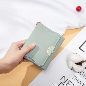 Vista dettagliata di un portafoglio tri-fold in pelle PU verde menta con fibbia a fiore