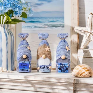 Ocean-themed knitted gnomes holding beach signs with starfish decor detail view