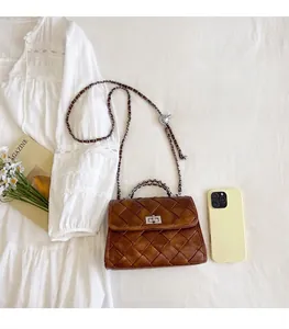 Gros plan du sac carré en cuir tressé marron vintage avec bandoulière chaîne