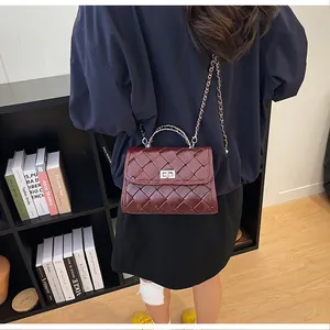 Vue arrière d'un mannequin portant un sac carré en cuir tressé bordeaux avec chaîne