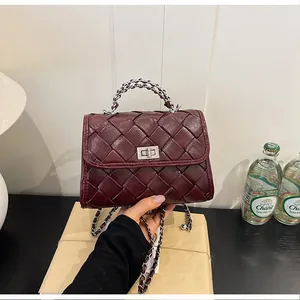 Détail d'un sac à main carré en cuir tressé bordeaux avec bandoulière chaîne argent