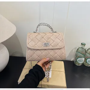 Sac à main en cuir tressé beige avec chaîne argentée et fermoir métallique détaillé.