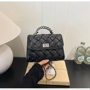 Vue détaillée d'un élégant sac à bandoulière tressé noir avec poignée en chaîne argent.