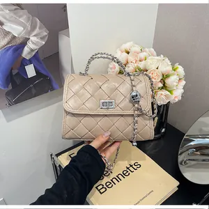 Vue détaillée d'un sac à main beige tressé avec chaîne argentée et fermoir en métal