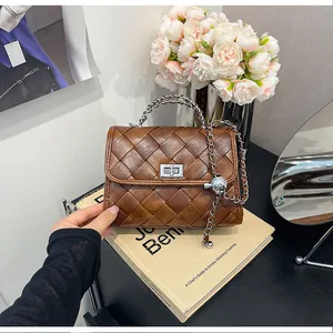 Gros plan d'un sac à main tissé marron vintage avec chaîne en métal argenté