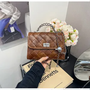 Gros plan d'un sac à main carré tressé marron vintage avec une chaîne argentée
