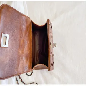 Vue détaillée du sac à bandoulière marron montrant sa capacité intérieure et sa texture.
