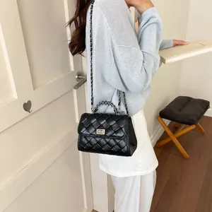 Sac à bandoulière élégant en cuir tressé noir pour femme avec chaîne de style.