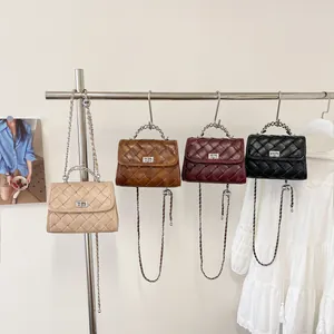 Petits sacs à main carrés rétro matelassés en quatre couleurs sur un support en métal.