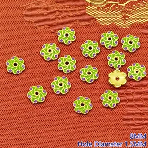 Close-up of 8mm green floral enamel alloy spacer beads for jewelry making