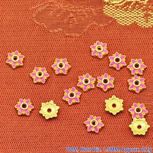 Macro view of pink enamel flower bead spacers with golden trim on textured background