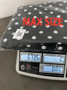 Medición del peso de unos pantalones vaqueros negros con lunares empaquetados talla L