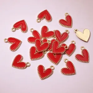 Close-up of red enamel heart charms with gold beaded borders for DIY jewelry