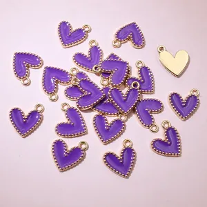 Close-up of purple heart charms with gold beaded edges for DIY jewelry.