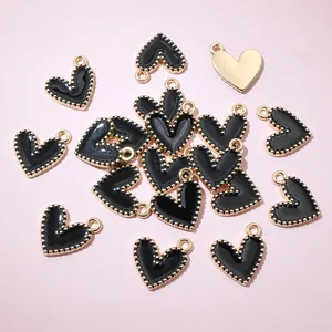 Close-up of black alloy heart pendants with gold beaded edges for DIY jewelry making crafts.