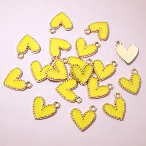 Detailed view of yellow alloy heart pendants with golden beaded edges for DIY jewelry.