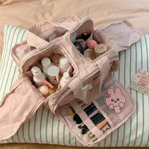 Macaron pink quilted cotton makeup bag with compartments for travel organization.