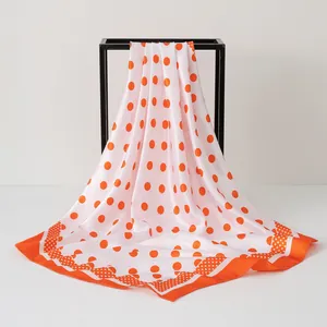 Elegant 90x90cm satin square scarf featuring a vibrant orange polka dot print pattern