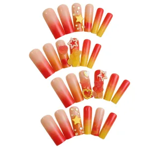 Long coffin press-on nails with gradient orange-red and 3D bear star charms