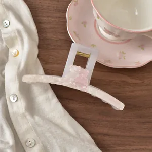 Detailansicht einer weißen Haarklammer mit süßem rosa Bärenmotiv und Spring-Schriftzug.